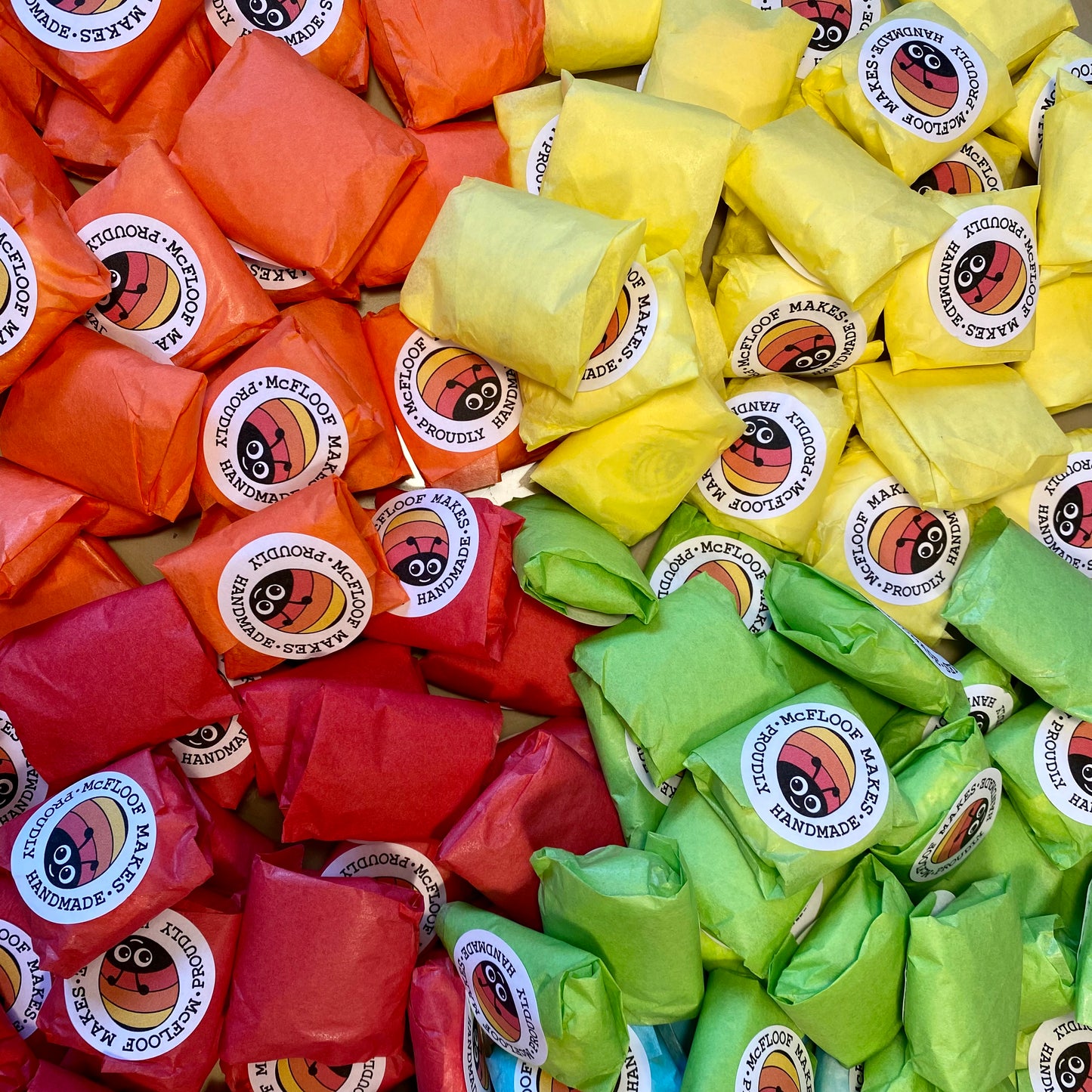 Pebbles wrapped in colourful tissue paper.