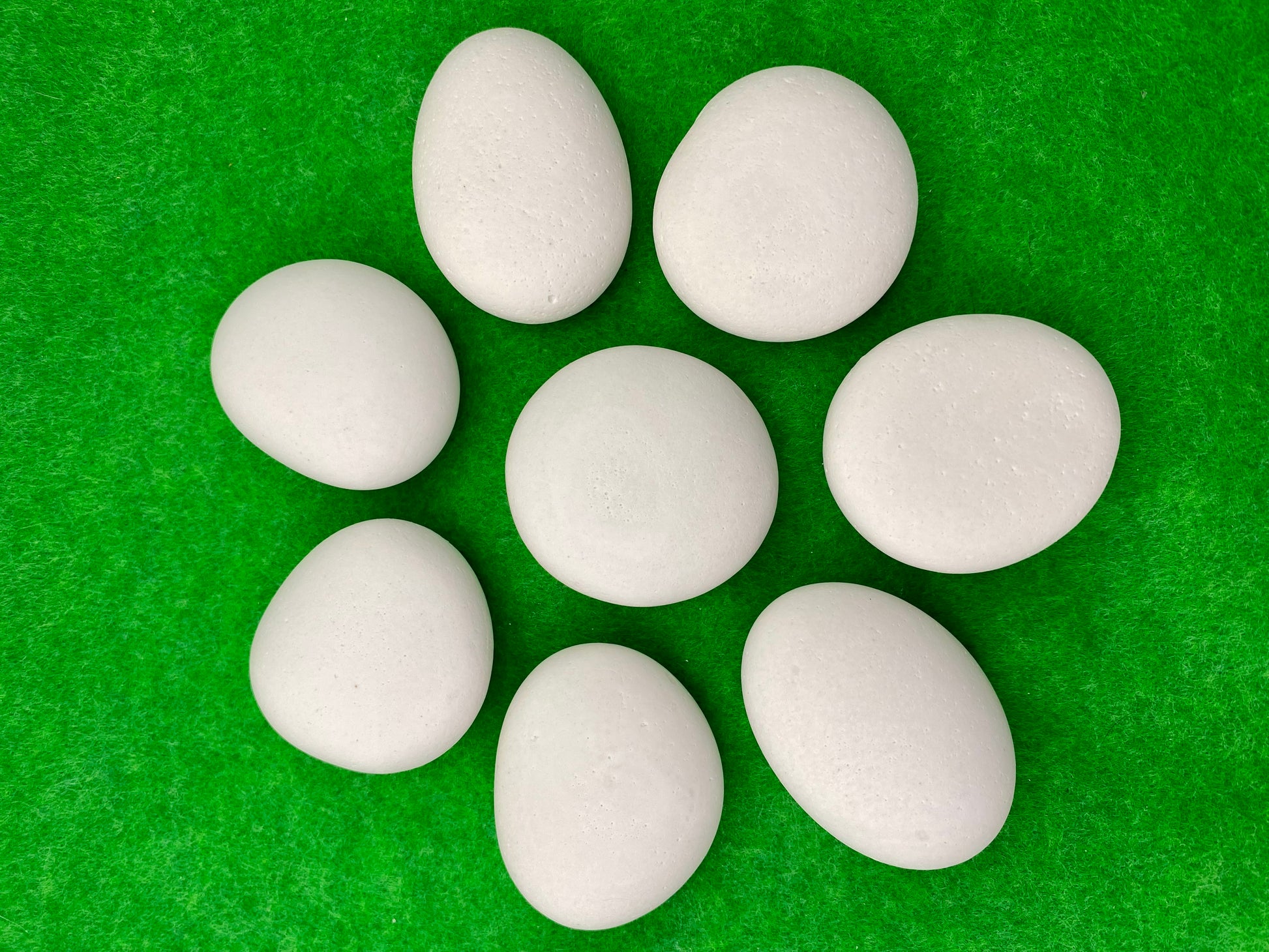 8 small white plaster pebbles of different shapes and sizes