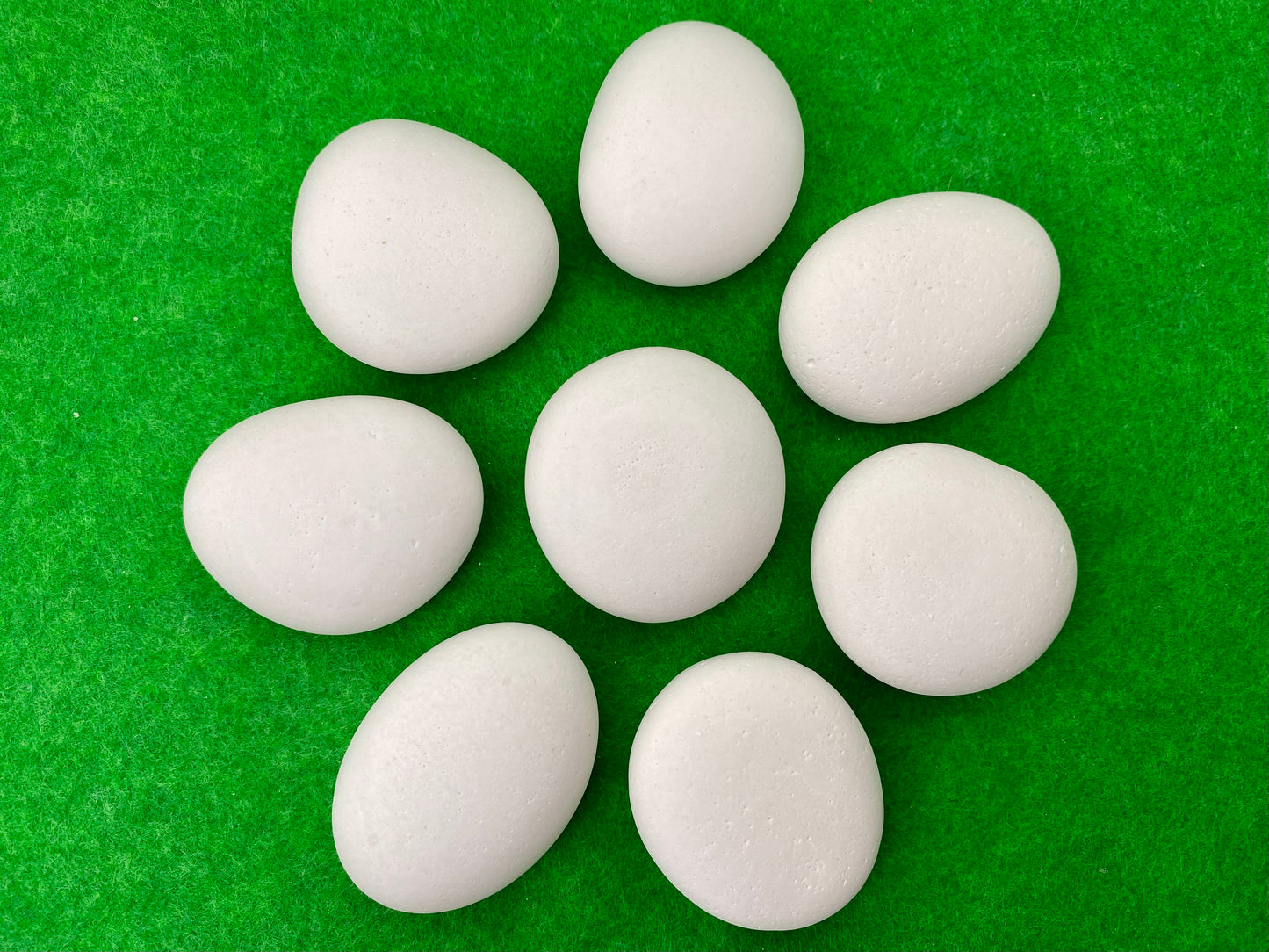 8 small white plaster pebbles of different shapes and sizes