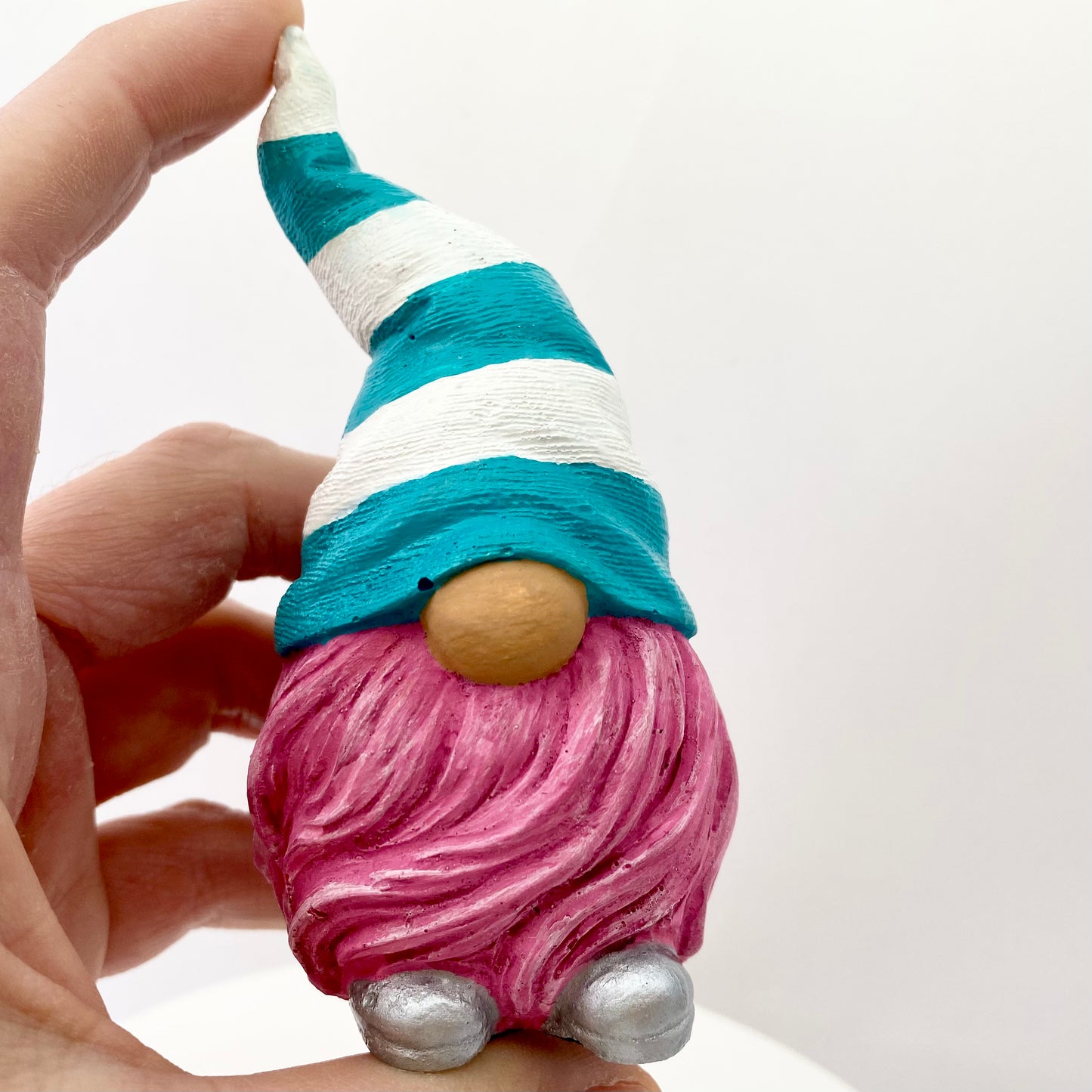 Hand painted Gonk statue with pink beard and teal and white striped hat  Edit alt text