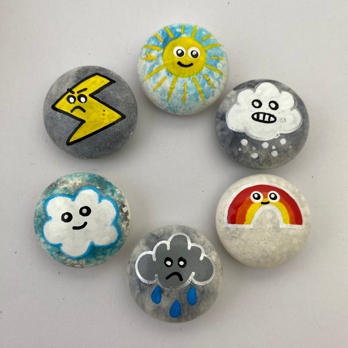 6 small hand painted weather themed pebbles