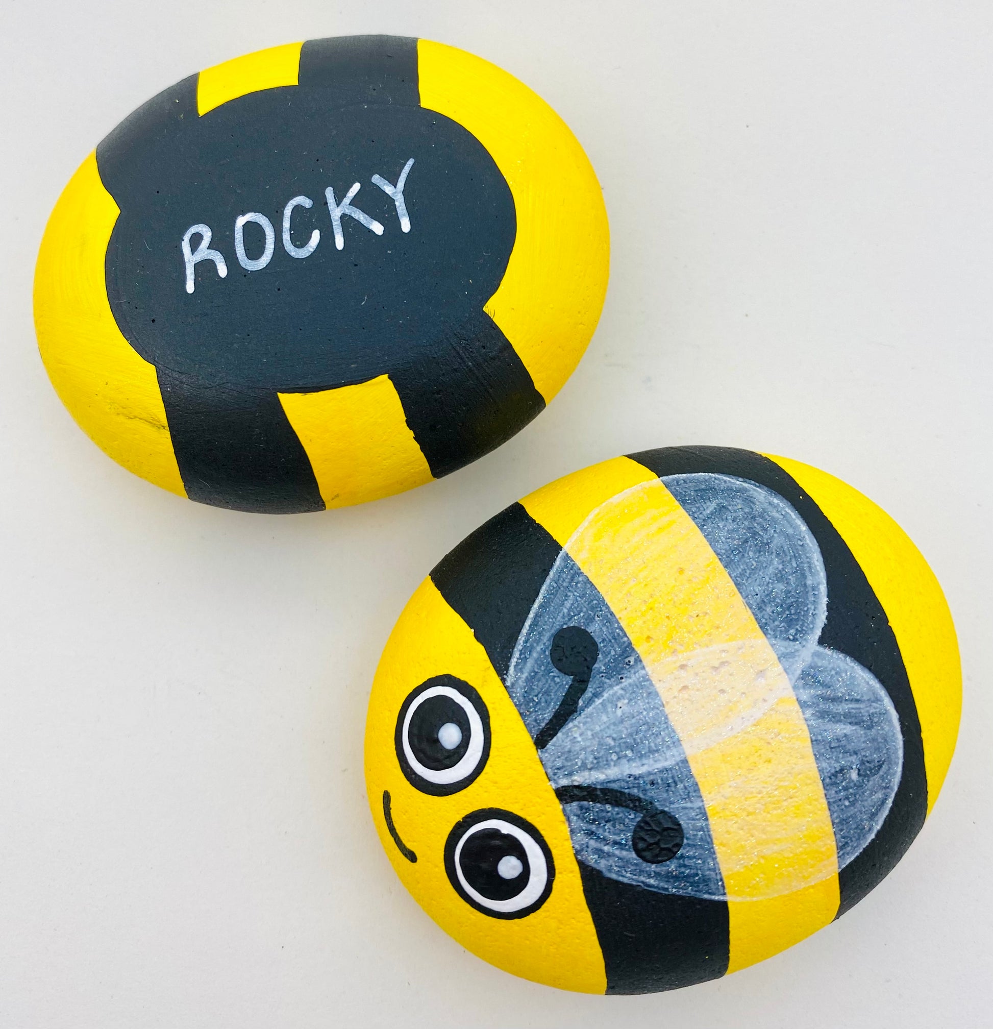 Hand painted Bee Pebbles showing Underside Personalised with the name Rocky