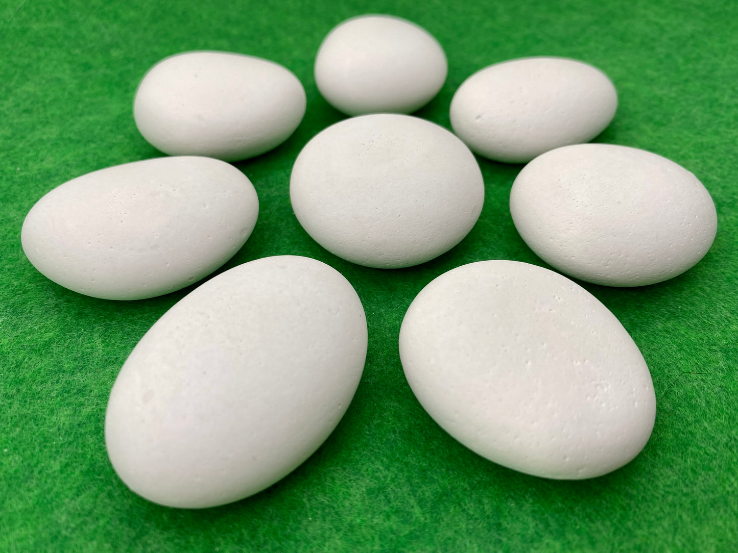 8 small white plaster pebbles of different shapes and sizes