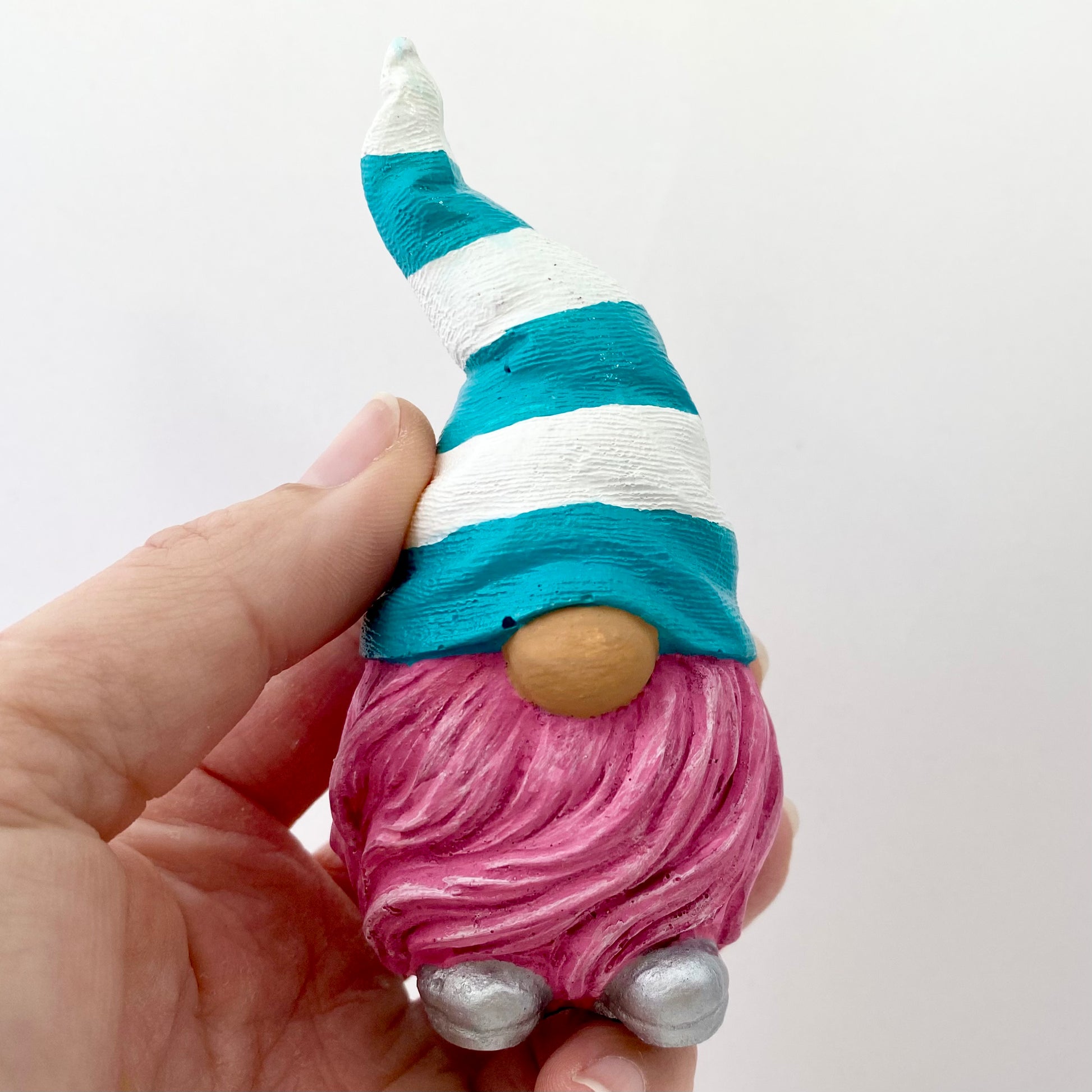 Hand painted Gonk statue with pink beard and teal and white striped hat  Edit alt text