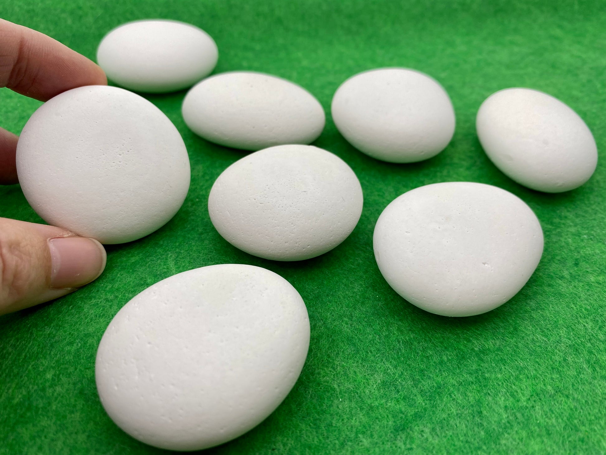 8 small white plaster pebbles of different shapes and sizes