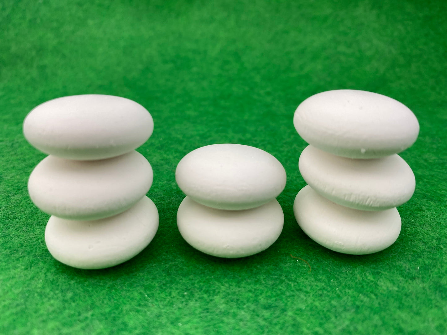 8 tiny white circular plaster pebbles stacked on top of each other