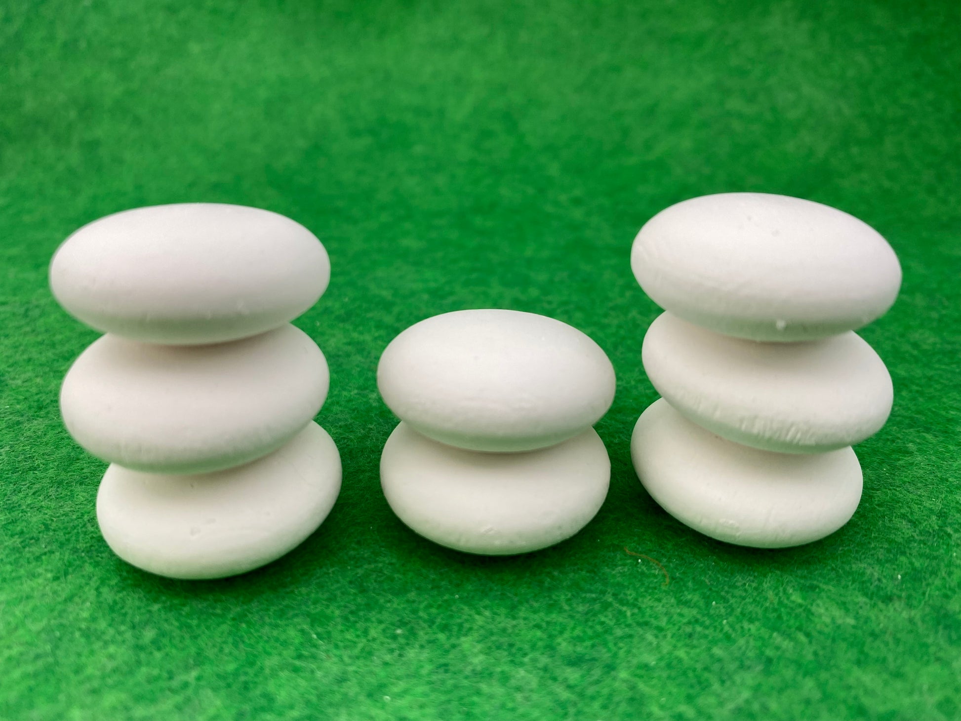 8 tiny white circular plaster pebbles stacked on top of each other