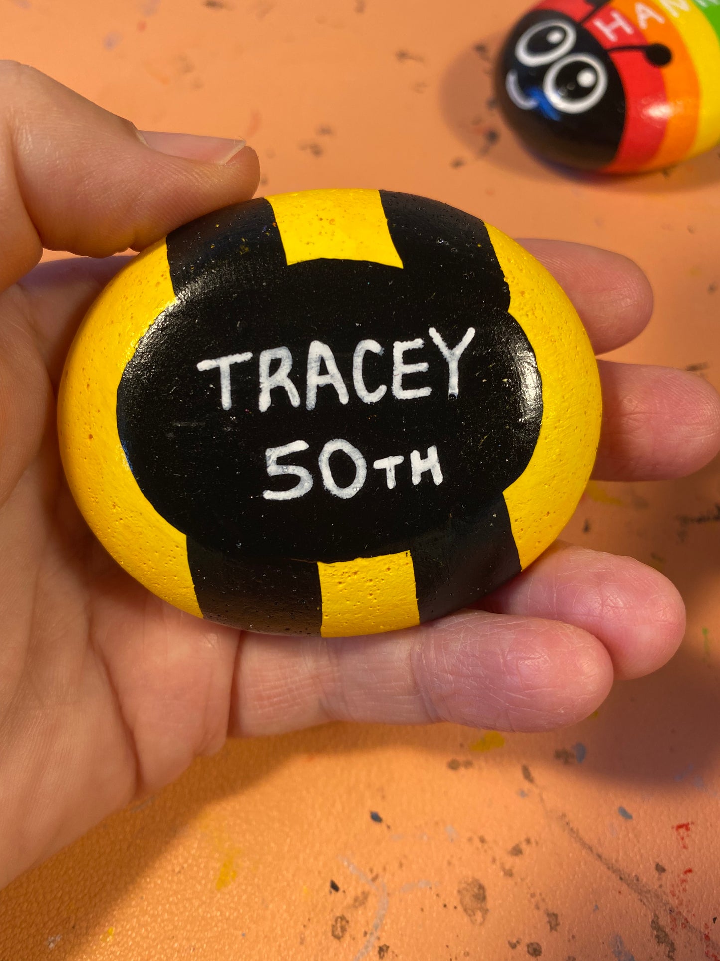 Hand painted Bee Pebble showing Underside Personalised with the words Tracey 50th