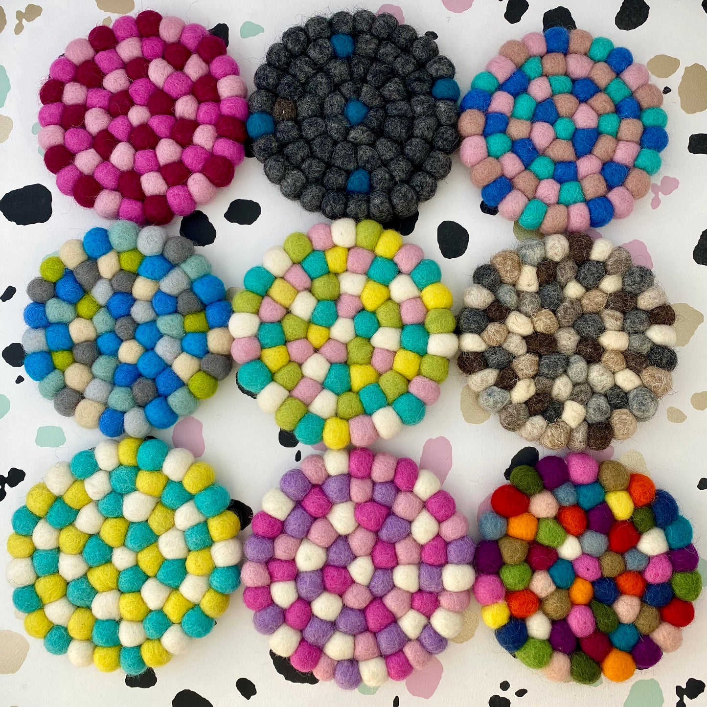 9 Coaster sized Mats made from Felt Balls in different colours.