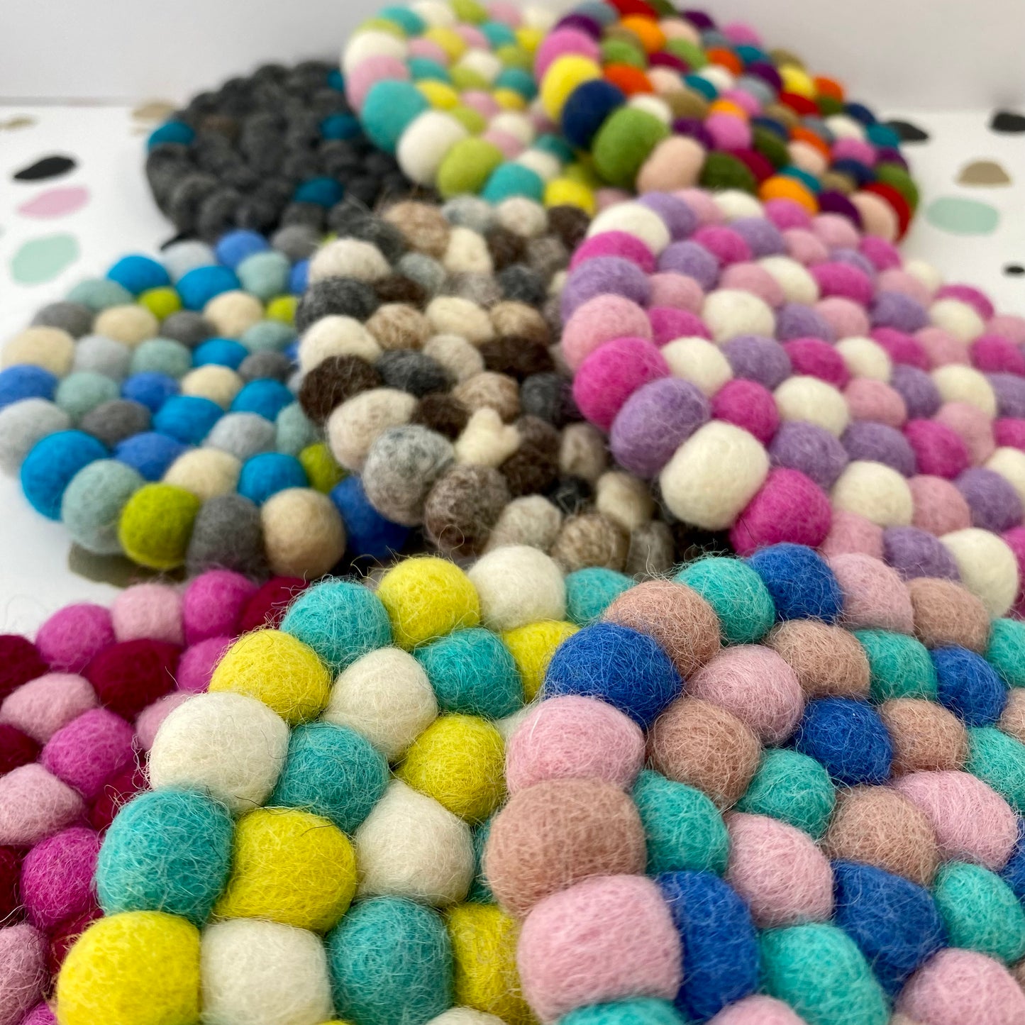 9 Coaster sized Mats made from Felt Balls in different colours.