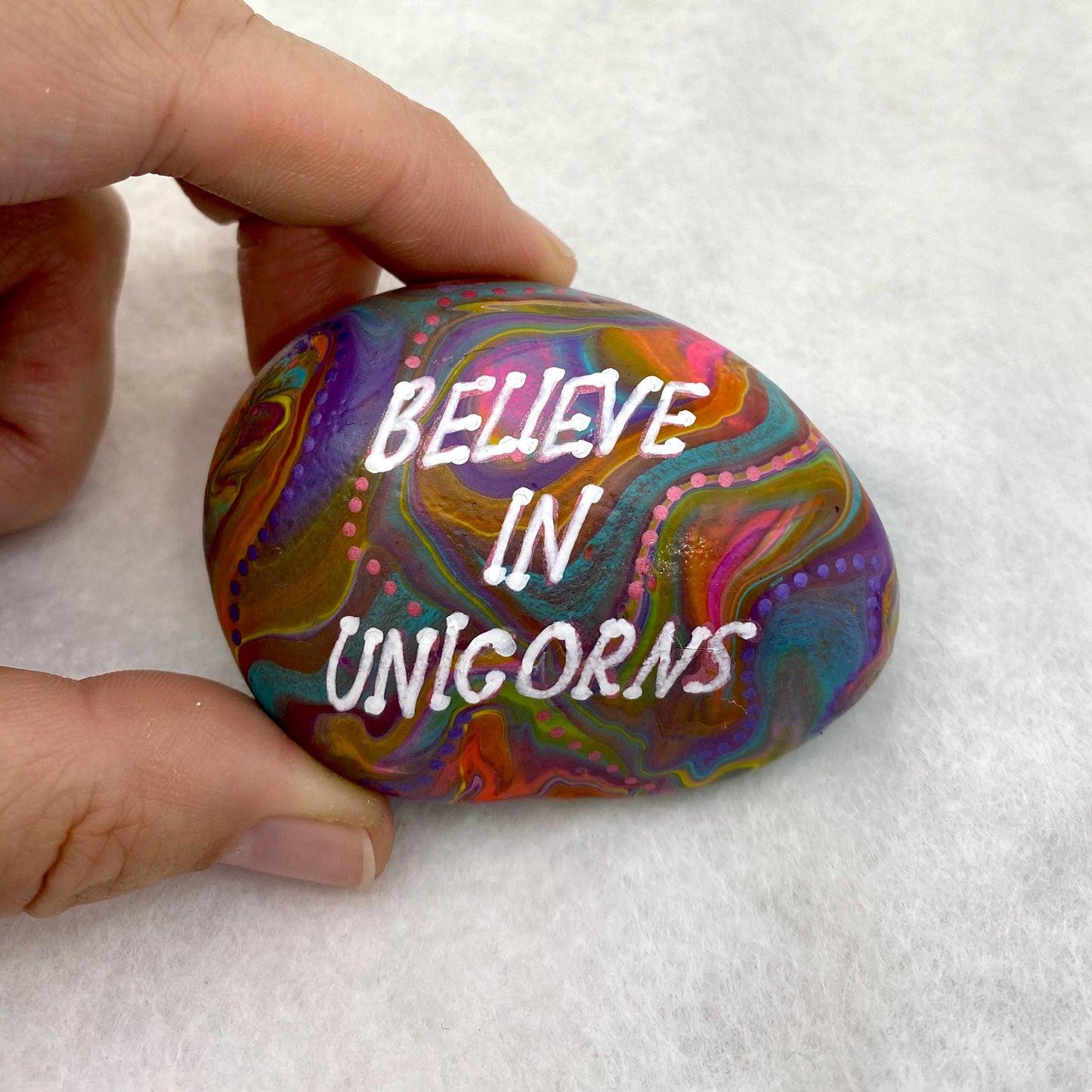 Colourful Hand painted Stone with the words Believe in Unicorns