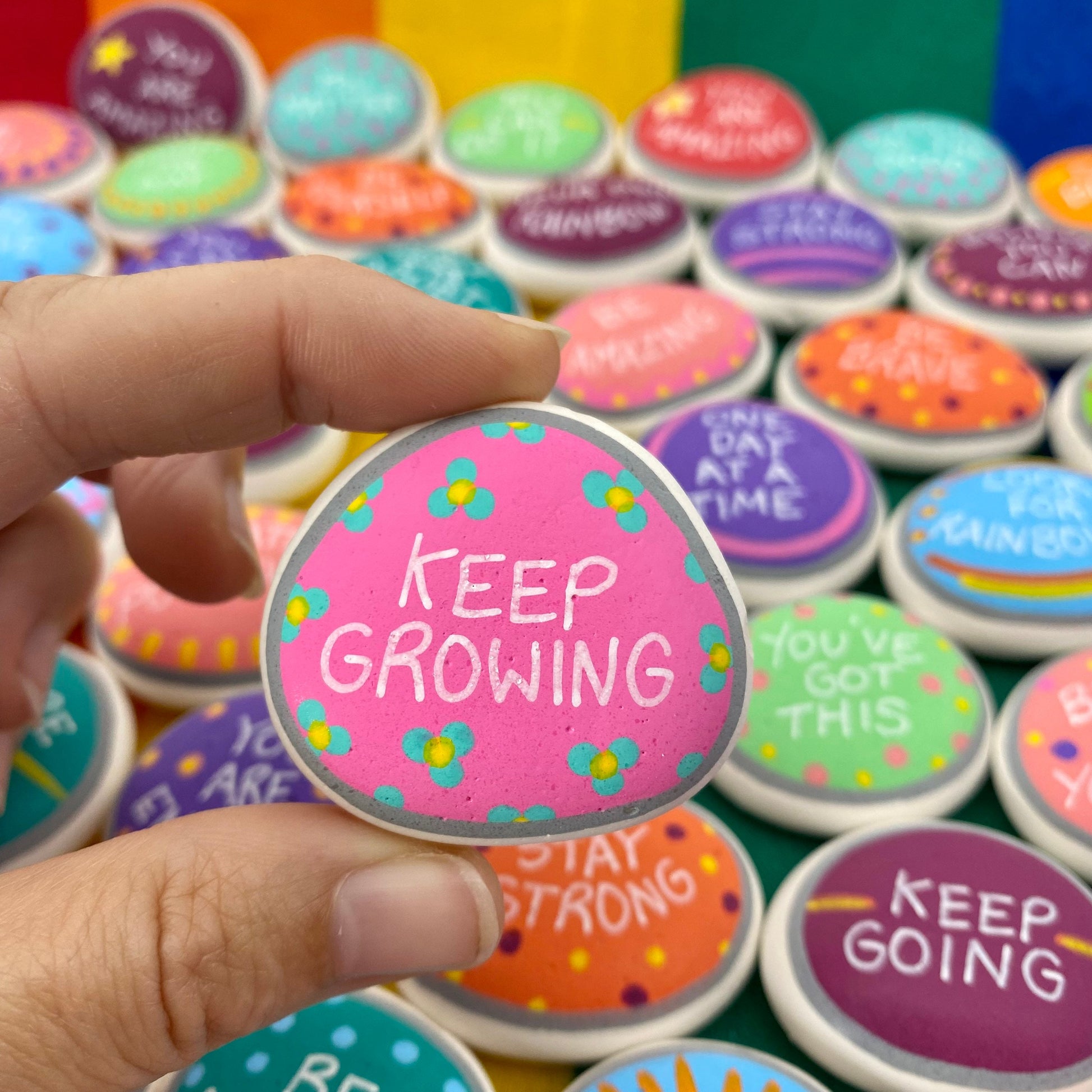 Colourful Hand painted pebble with the words Keep Growing written on