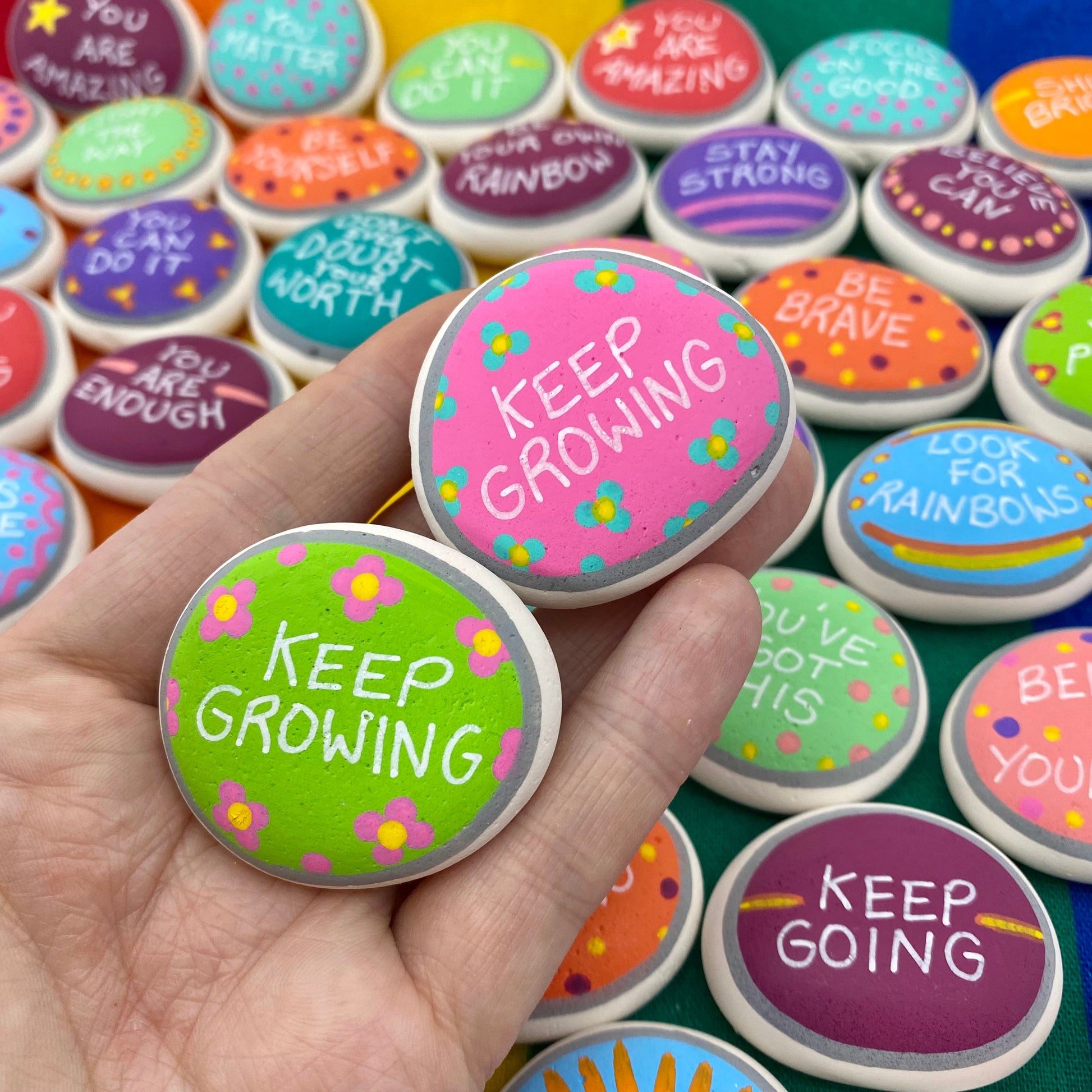 Colourful Hand painted pebbles with the words Keep Growing written on