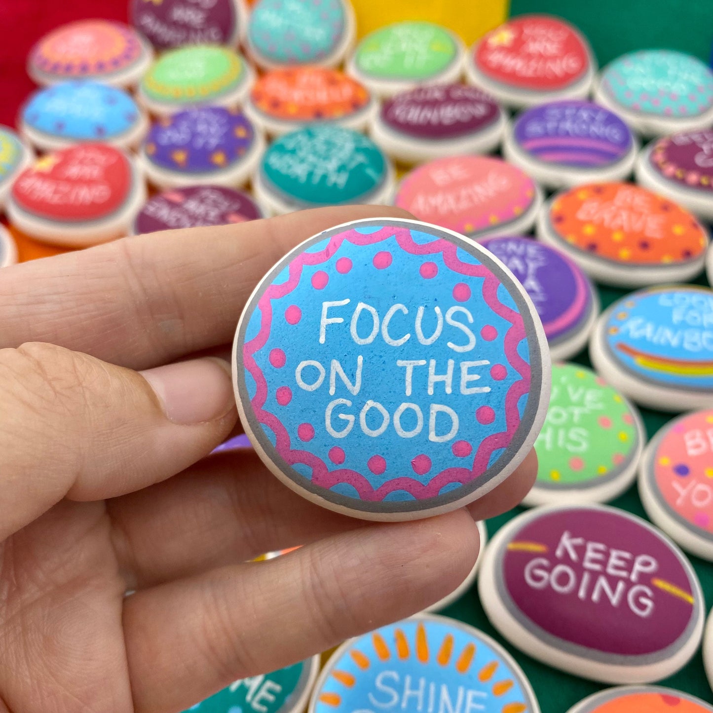 Colourful Hand painted pebble with the words Focus on the Good written on