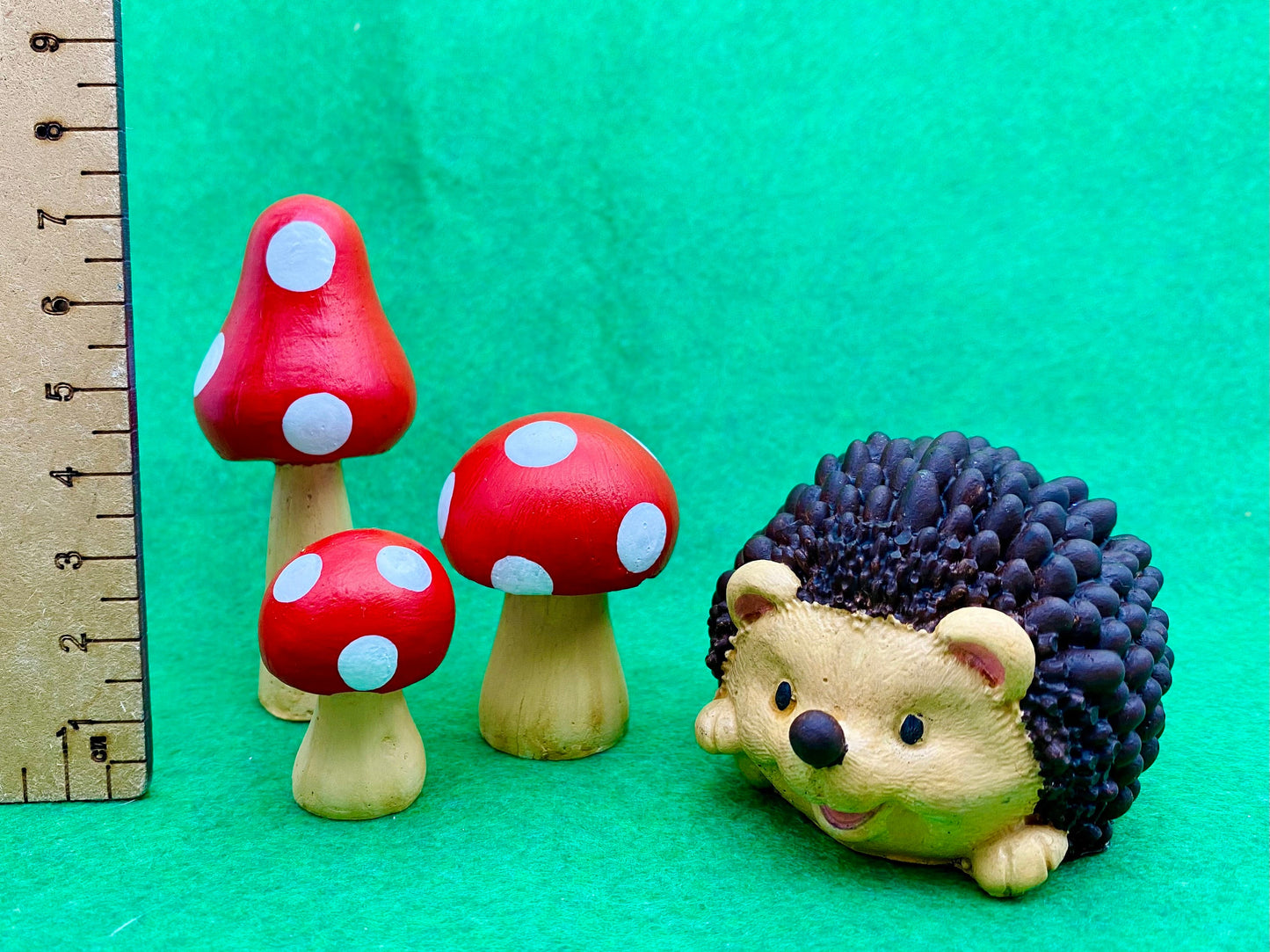 Hand painted Hedgehog and toadstools ornaments next to a ruler