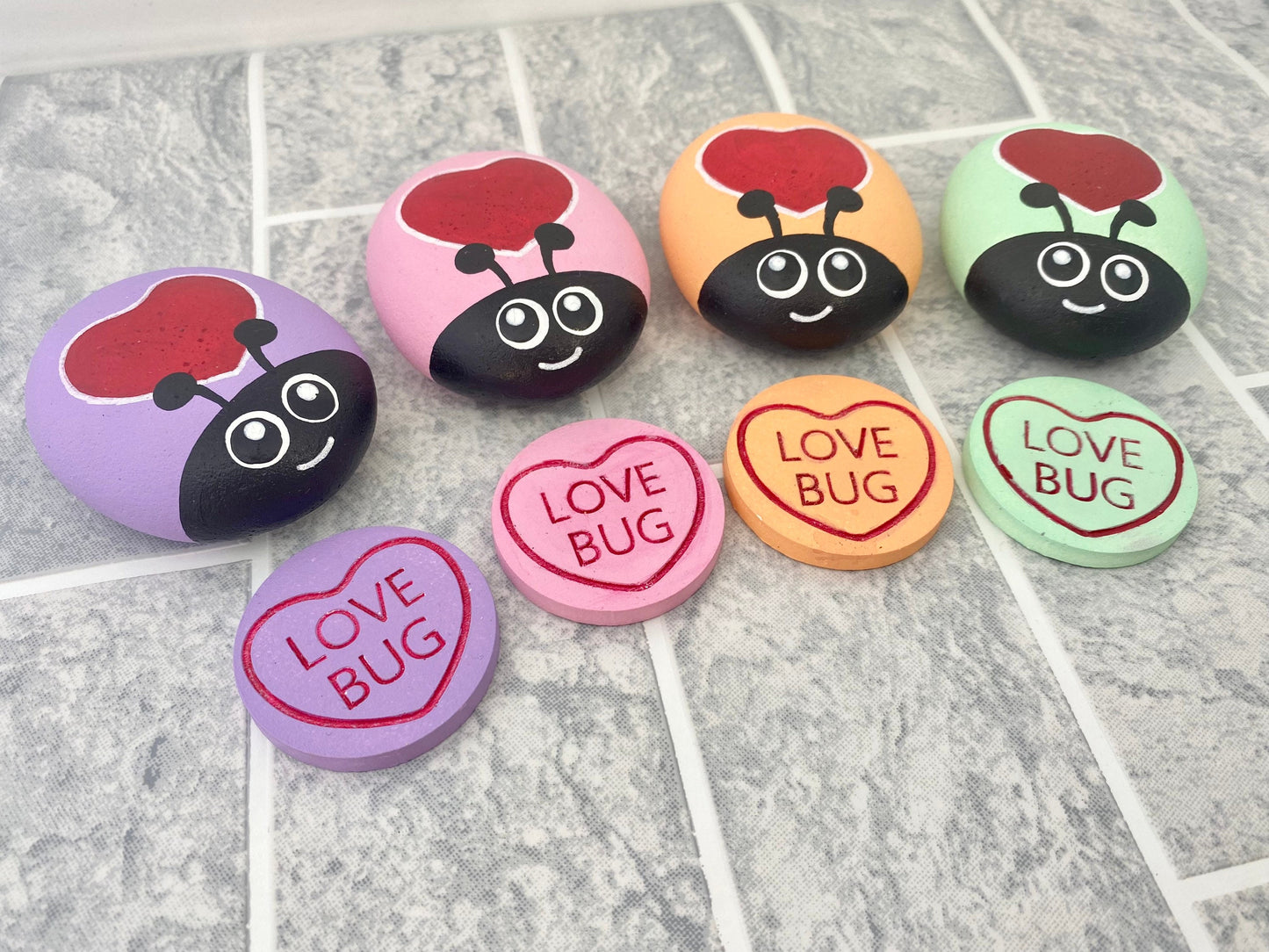 4 Hand painted Pastel Heart Bug Pebbles and Tokens with the words Love Bug inscribed on