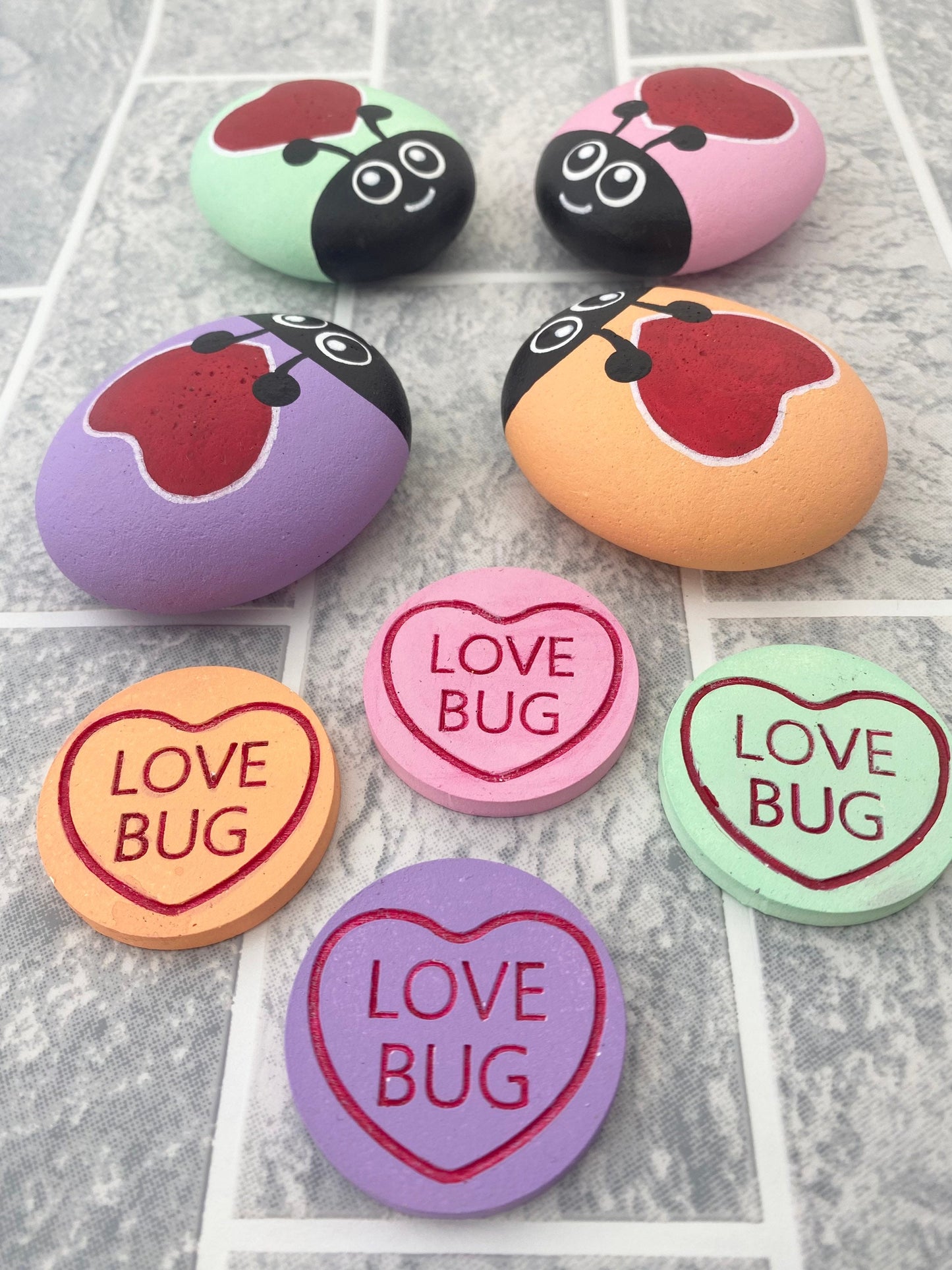 4 Hand painted Pastel Heart Bug Pebbles and Tokens with the words Love Bug inscribed on