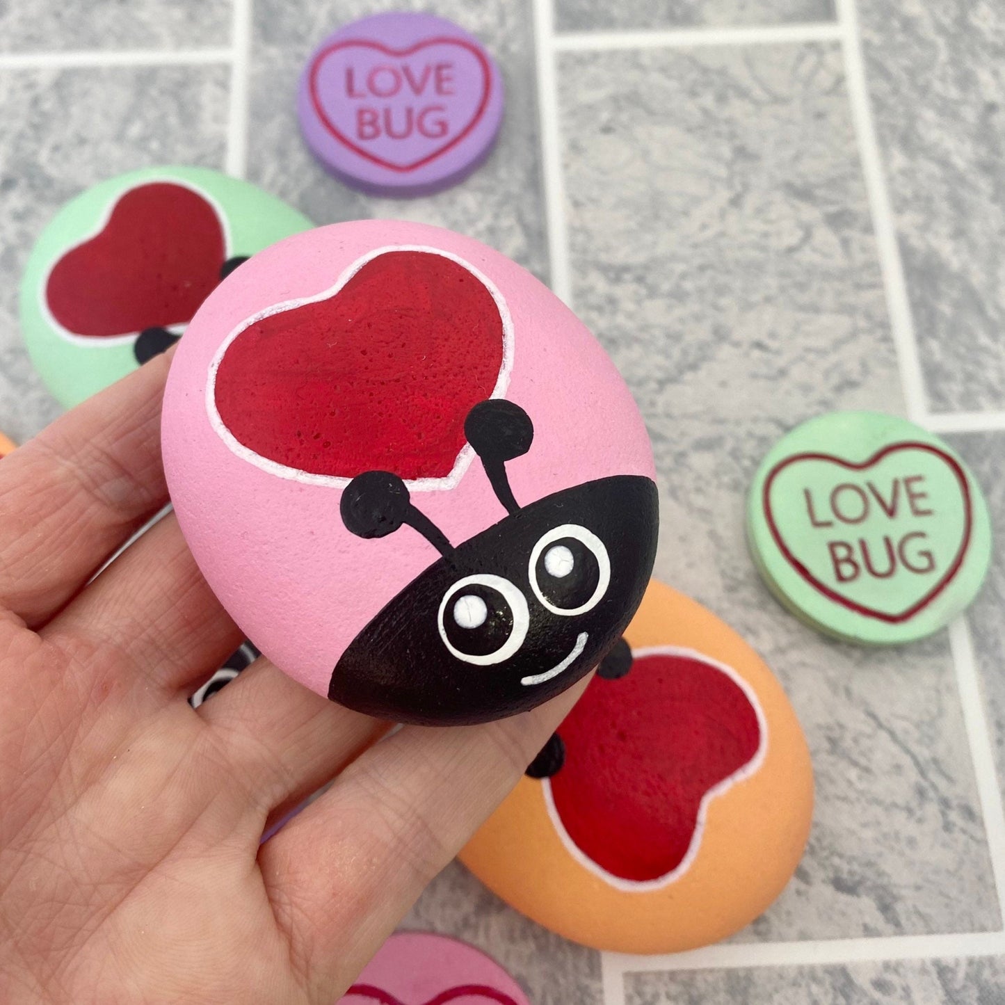 Hand painted Pastel Heart Bug Pebbles and Tokens with the words Love Bug inscribed on