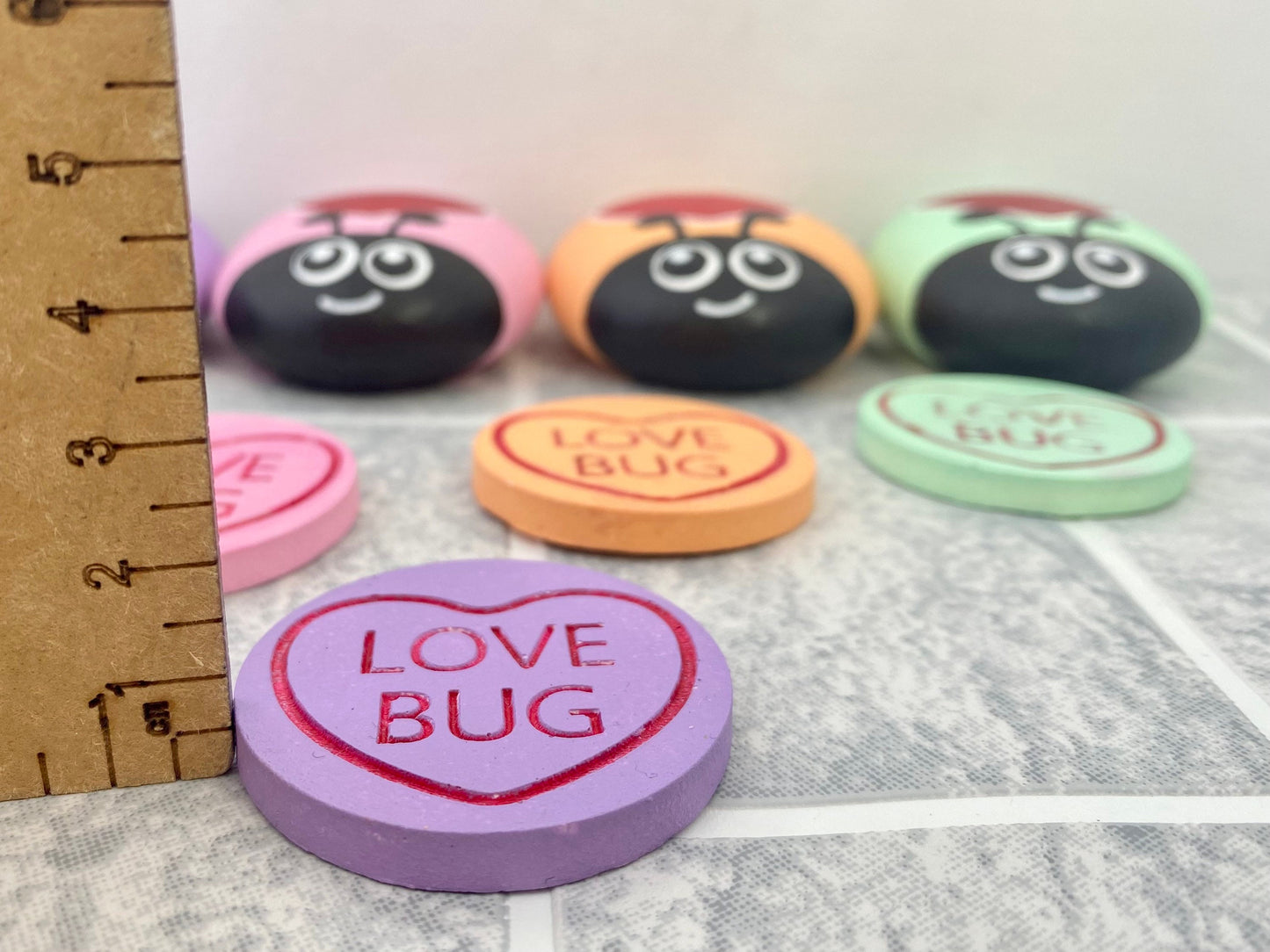 Pastel Purple Token with the words Love Bug inscribed on next to a ruler